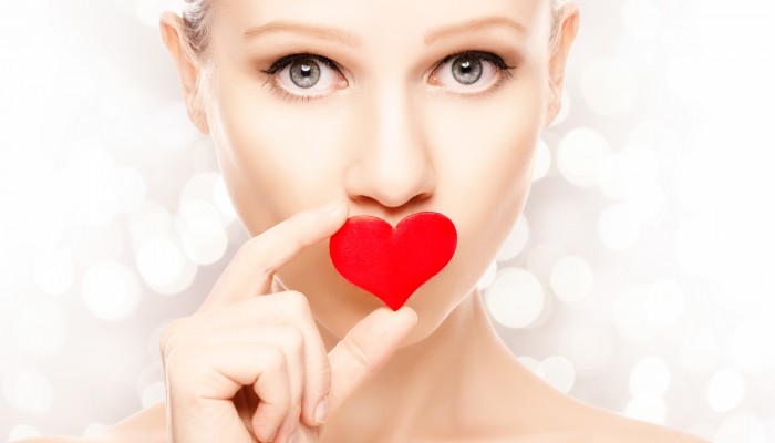 concept of Valentine's Day. beautiful girl with a red heart on lips